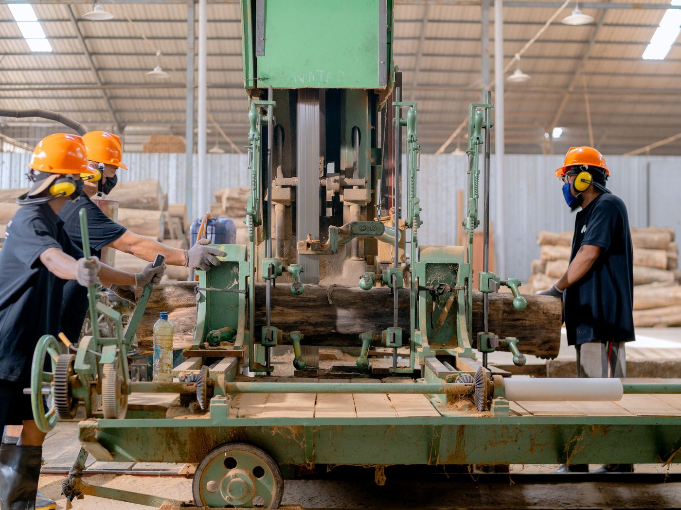Operators working a log through the sawmill carriage